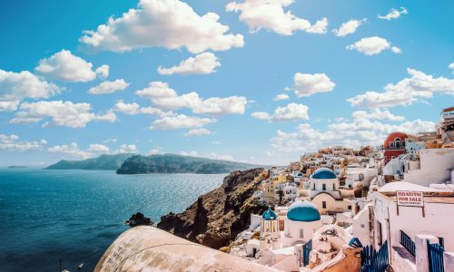 Captivating view of Santorini's famous blue-domed buildings under a vibrant sky.